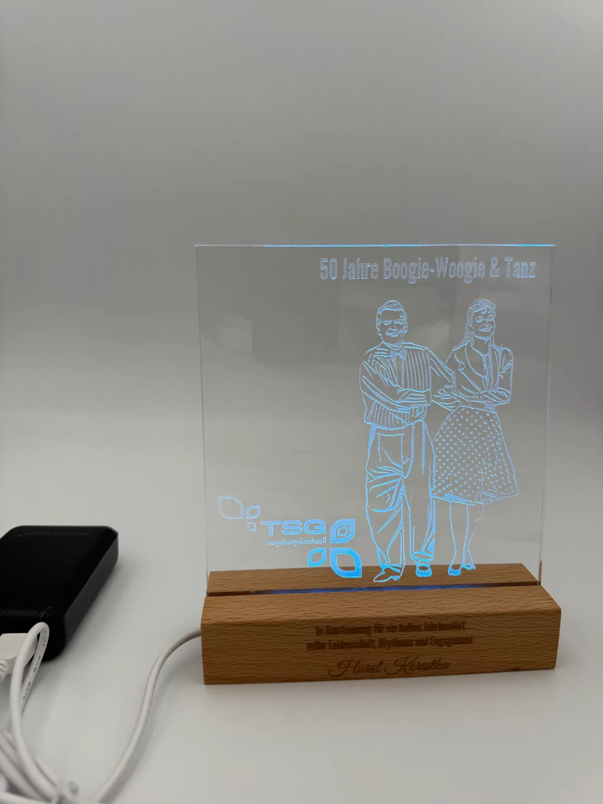Graviertes Acryl-Display mit tanzendem Paar, blau beleuchtet auf Holzsockel