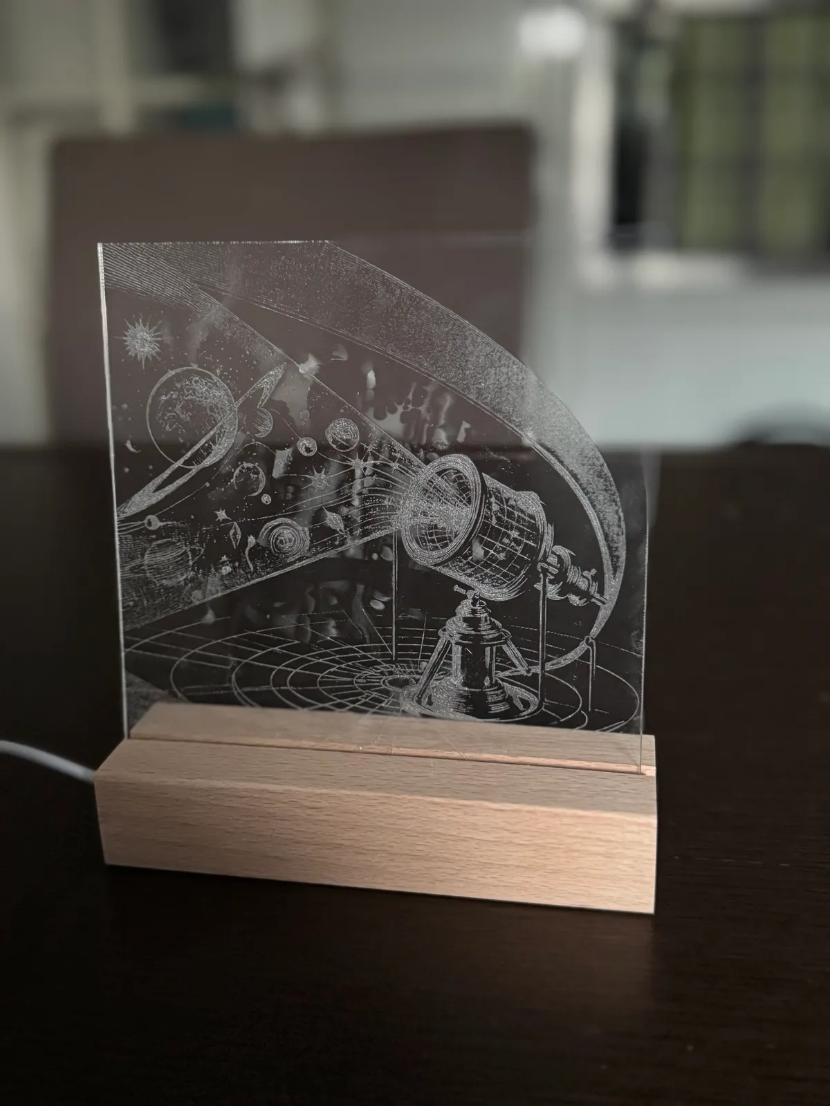Graviertes Acrylglas mit astronomischem Motiv auf beleuchtetem Holzsockel