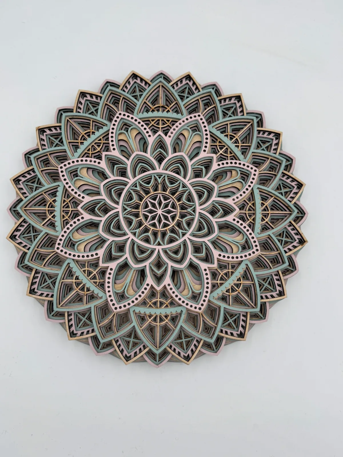 Mehrschichtiges Holz-Mandala in Blütenform in zarten Pastelltönen aus Mint, Rosé und Naturholz
