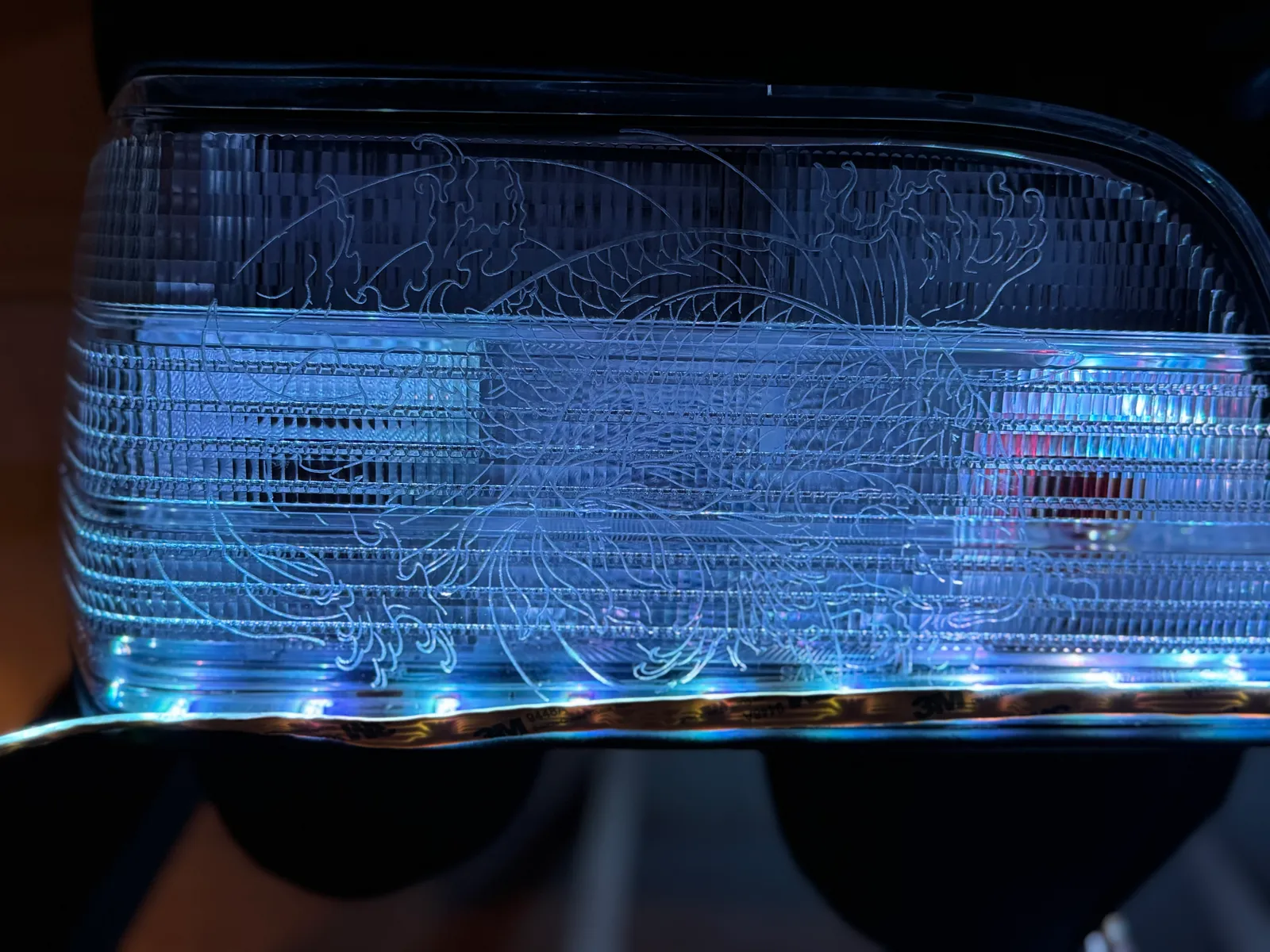 Fahrzeug-Rückleuchte mit fein lasergraviertem Drachenmotiv, blau hinterleuchtet